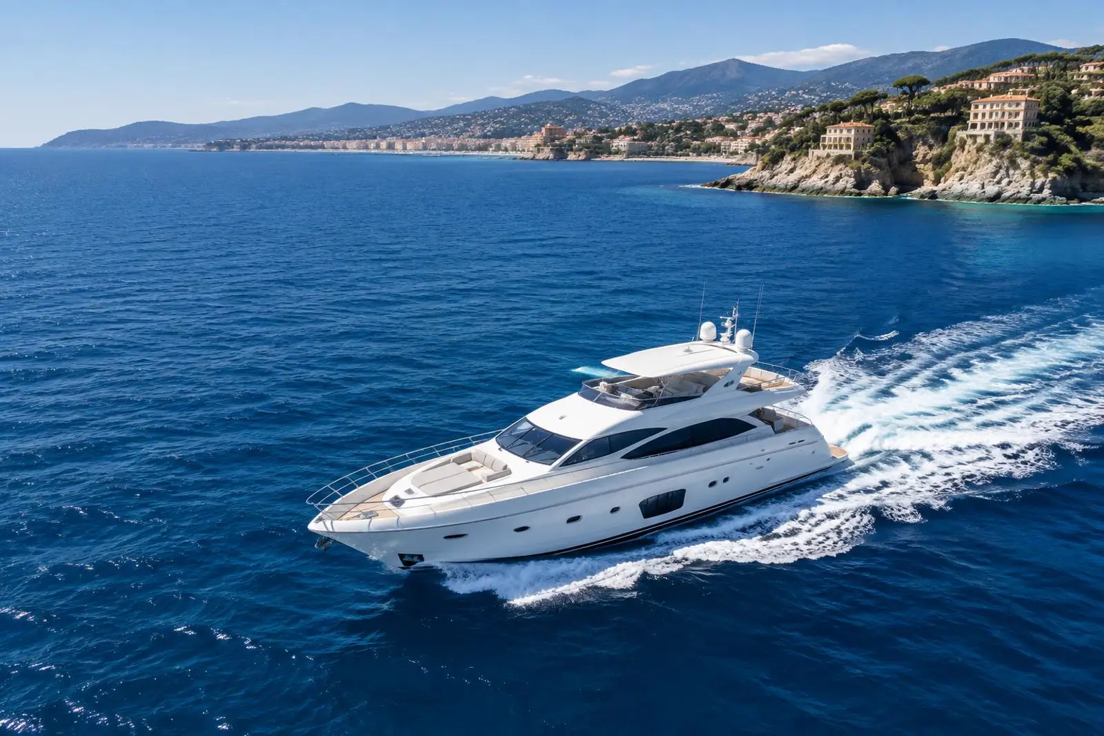 A white motor yacht cruising along the French Riviera